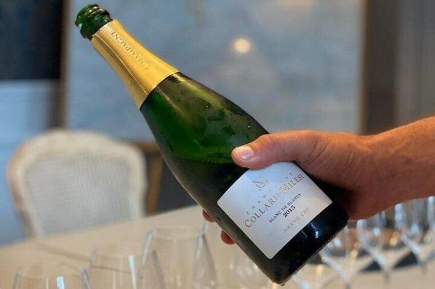 Una mano sosteniendo una botella de vino con una etiqueta que dice 'COTILLARD MILLET'. 4