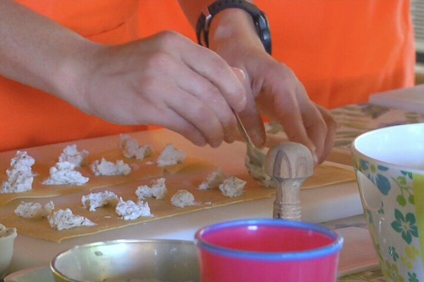 A person using a wooden mallet to crush something on a cutting board. 4