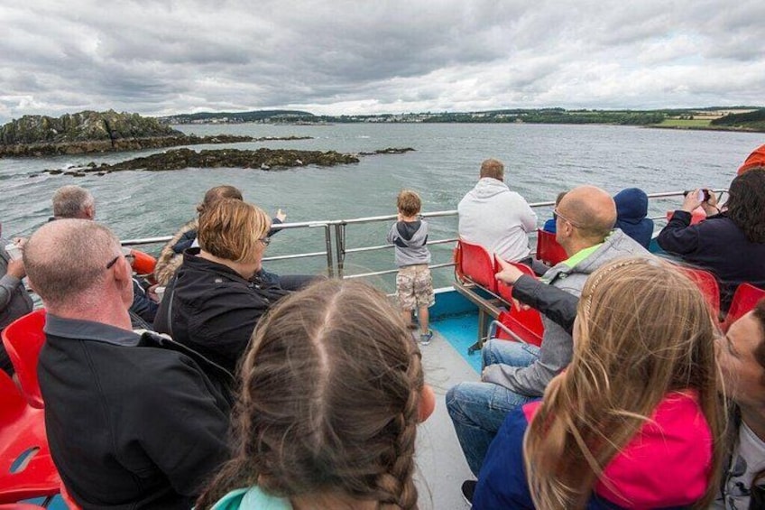 People on a boat, looking at the water and land. 2