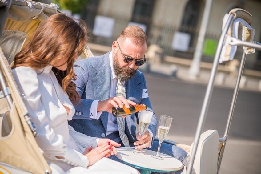 Un homme et une femme sont assis à une table, devant une bouteille et un verre, et semblent être en train de déguster une boisson. 4
