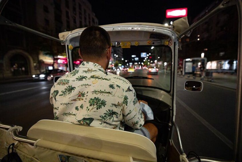 Une personne conduisant un véhicule de nuit, avec les lumières de la ville en arrière-plan. 3