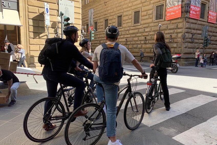 People on bicycles, a pedestrian crossing, and buildings with signage. 5
