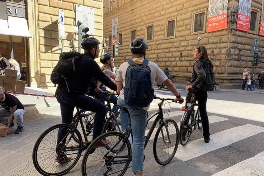 People on bicycles, a building with a sign, and a crosswalk. 4