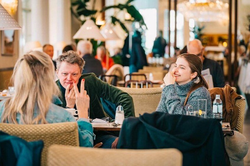 En restaurant indeni med mennesker, der spiser ved borde og stole. 4