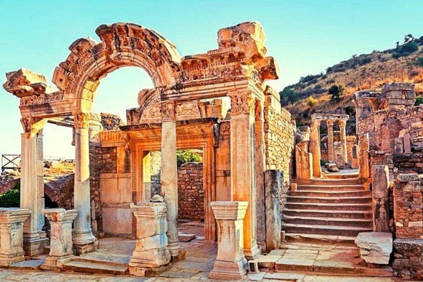 Ancient ruins with columns and arches, a staircase leading up, and a stone pathway. 2