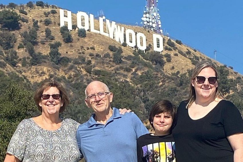Een groep mensen staat voor het Hollywood-bord. 1