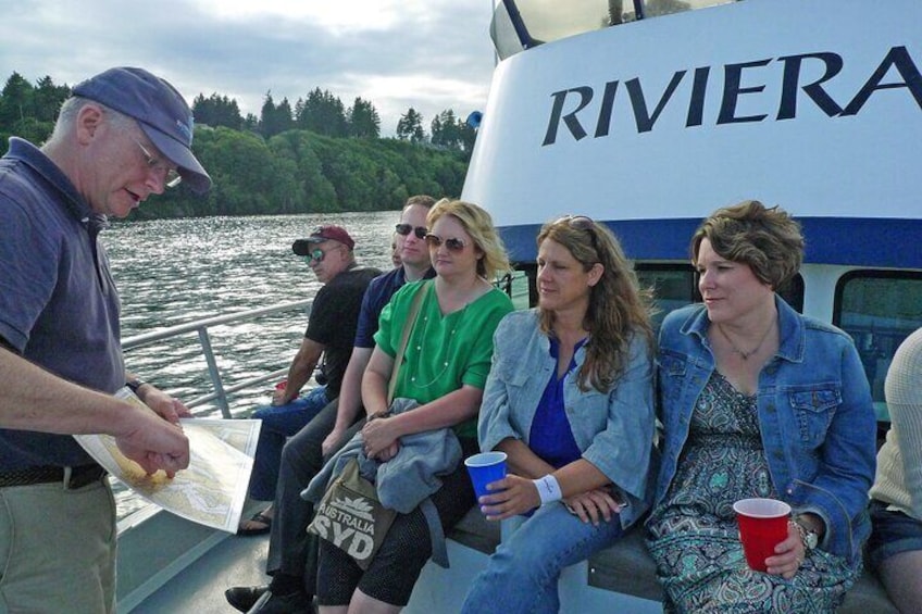 People on a boat with 'RIVIERA' written on the side, sitting and holding drinks. 3