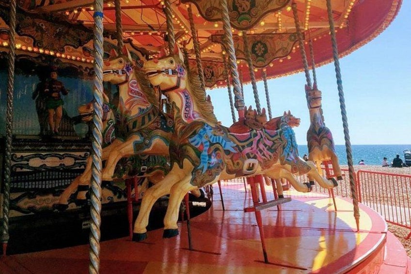 Un carrusel con caballos de colores y una persona montando uno. 2