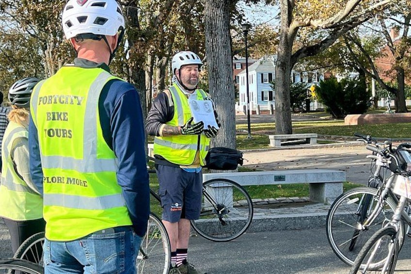 Two people in safety vests standing next to bicycles on a sidewalk. 5