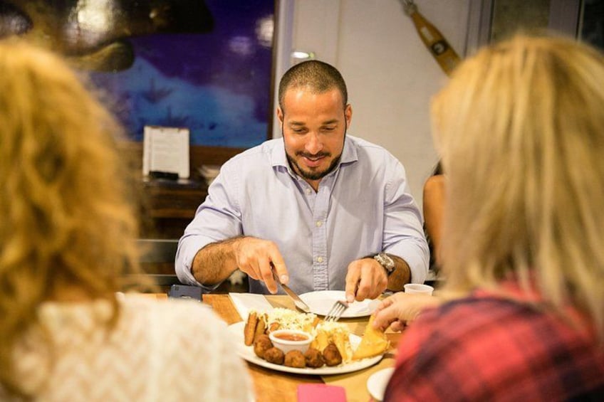 A person dining at a restaurant with a plate of food and a menu in the background. 2