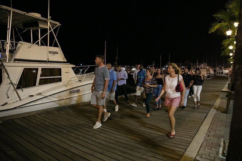 En träbrygga med folk som promenerar längs den under kvällen eller natten. 3