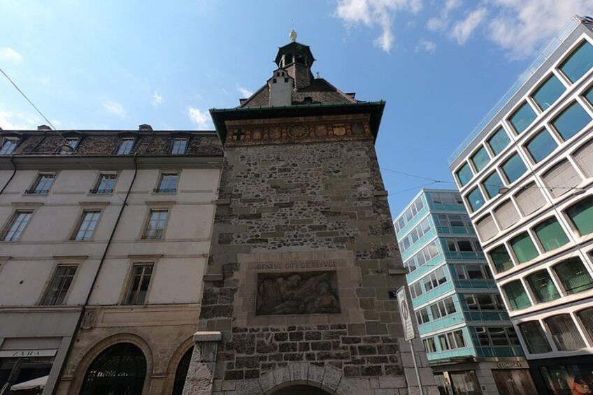 Une tour de pierre historique, dotée d’une horloge, entourée de bâtiments modernes. 4