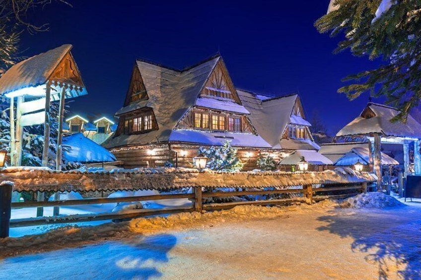 A snow-covered village with wooden houses and a wooden fence. 5