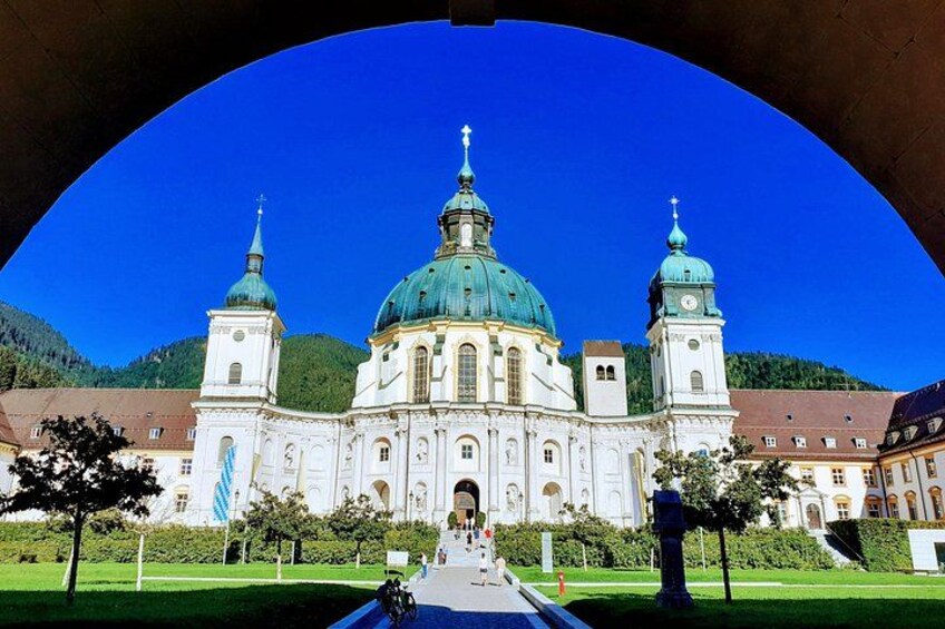 A large white church with a green dome and two towers, surrounded by a well-maintained lawn and trees. 4