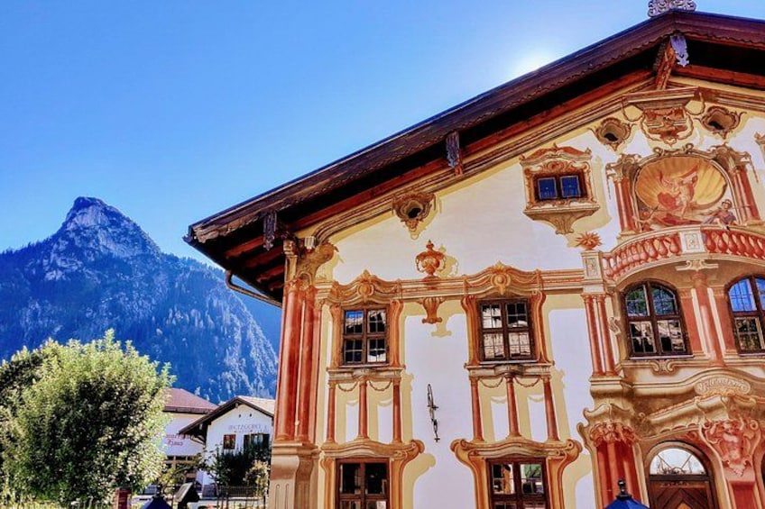 A building with ornate architecture, a mountain in the background, and a clear sky. 5