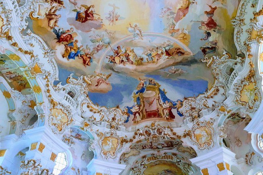 A detailed ceiling with ornate frescoes and gold accents. 3