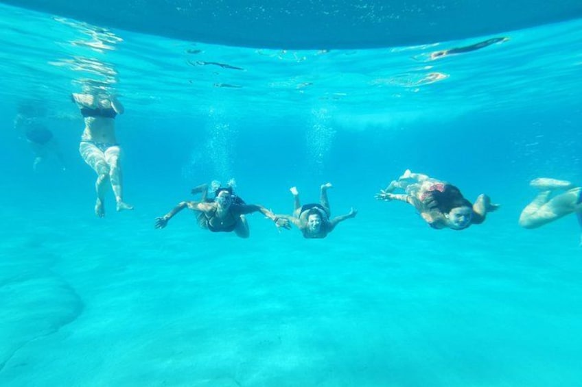 Des personnes nagent sous l’eau dans une piscine aux eaux bleues et cristallines. 5