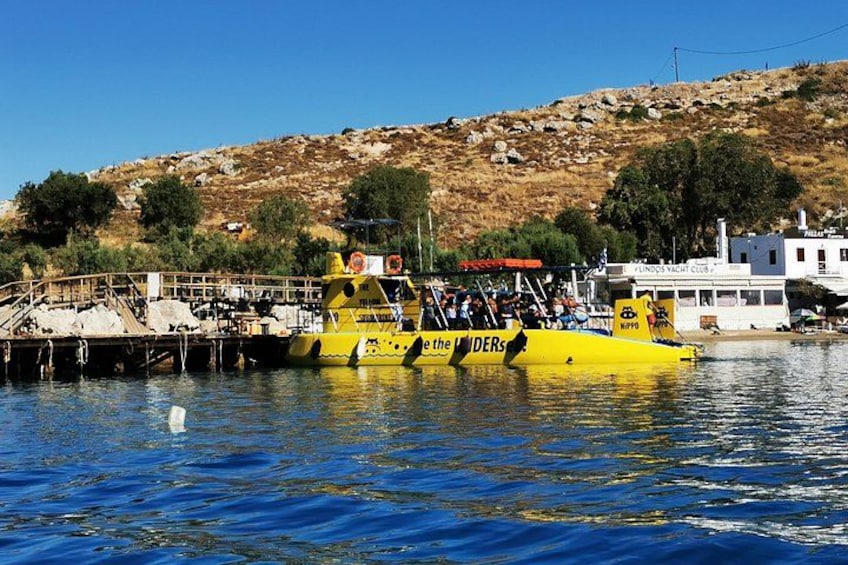Un bateau jaune était amarré à un quai, avec une colline rocheuse en arrière-plan. 4
