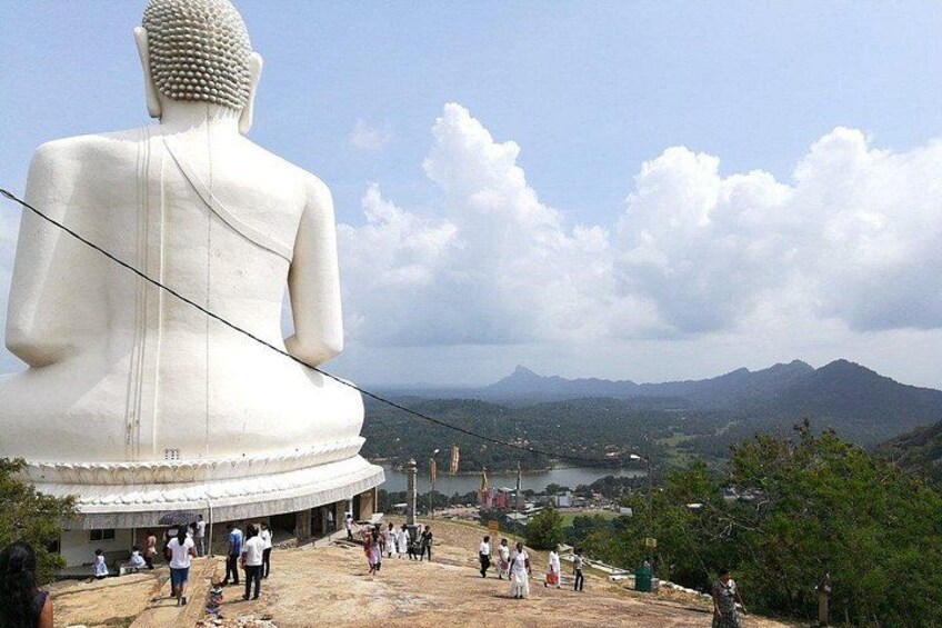 Une grande statue de Bouddha blanche, un paysage montagneux et un groupe de personnes. 3