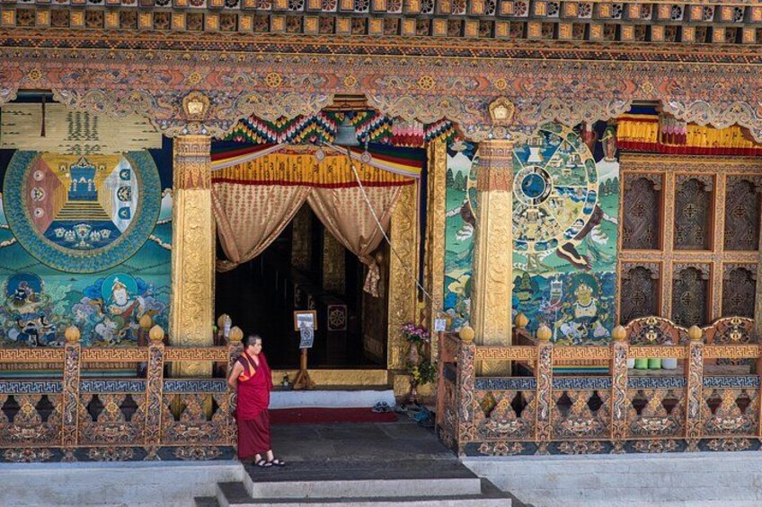 A colorful temple entrance with intricate murals and a large statue. 1