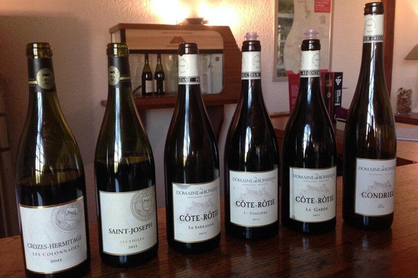 Six bottles of wine on a wooden table. 2