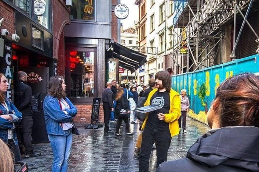 A street scene with pedestrians, a person in a yellow jacket, and a building with a sign that reads 'The Club.' 2