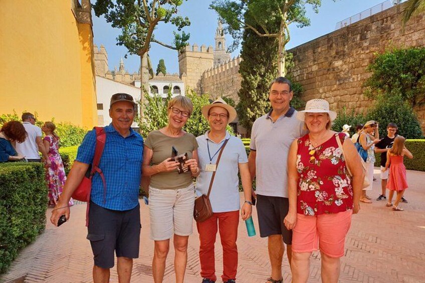 Eine Gruppe von Menschen steht vor einer historischen Stätte mit Steinmauern und einem Turm im Hintergrund. 5