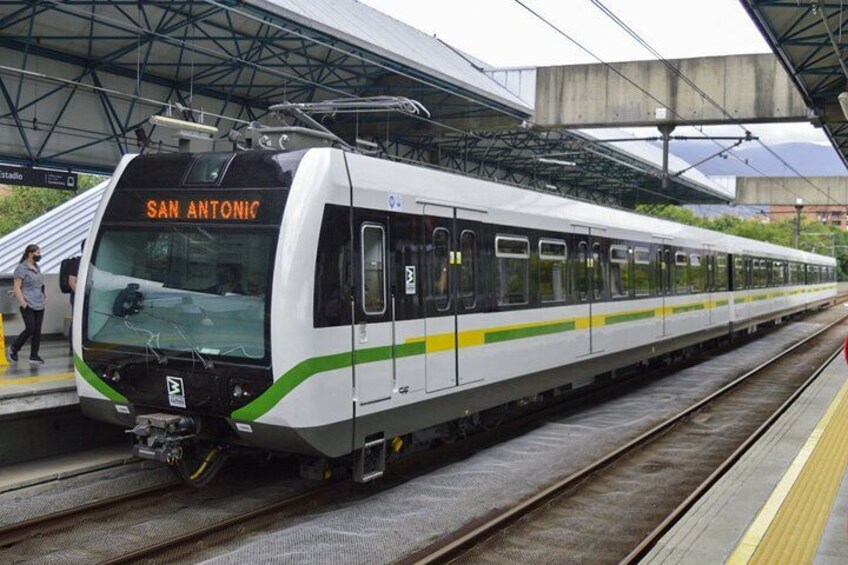 Un tren moderno en una estación, con 'SAN ANTONIC' exhibido en la parte frontal. 2