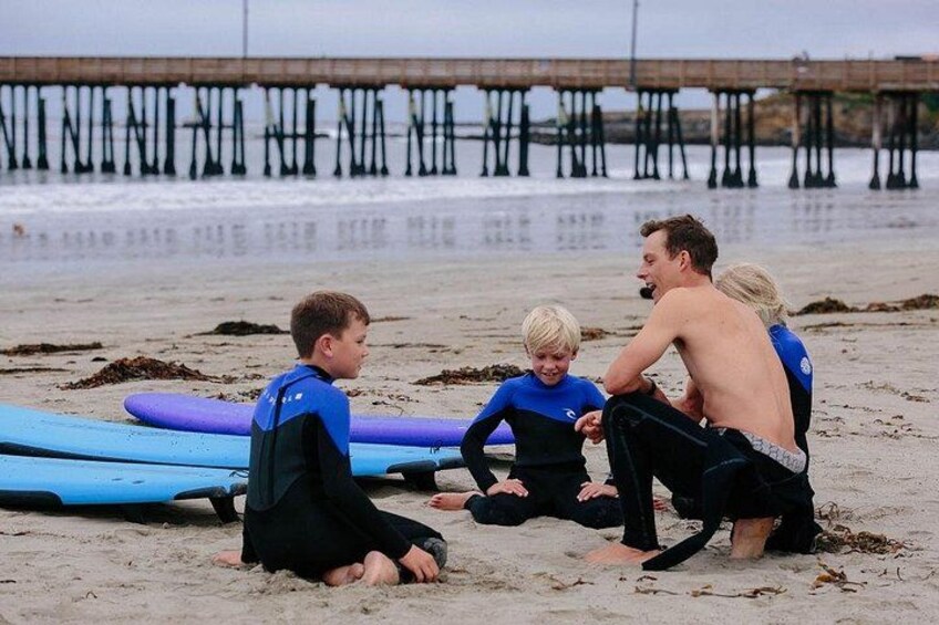 A beach with surfboards and a pier in the background. 4
