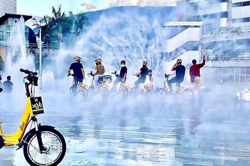 A group of people on scooters with a yellow bike in the foreground. 4