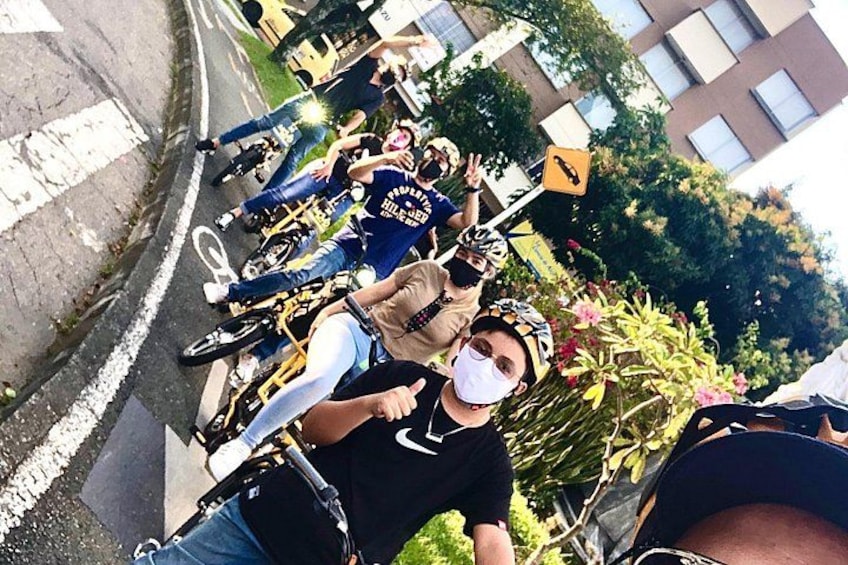 A group of cyclists on a street, wearing helmets and casual clothing. 3