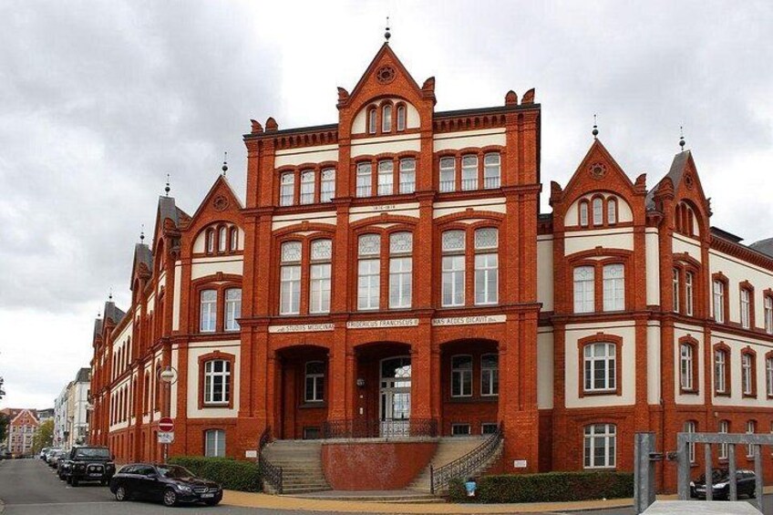 A large red brick building with multiple windows and a prominent entrance. 2