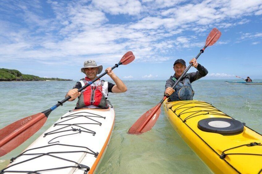 Two people kayaking on calm waters with a clear sky. 3