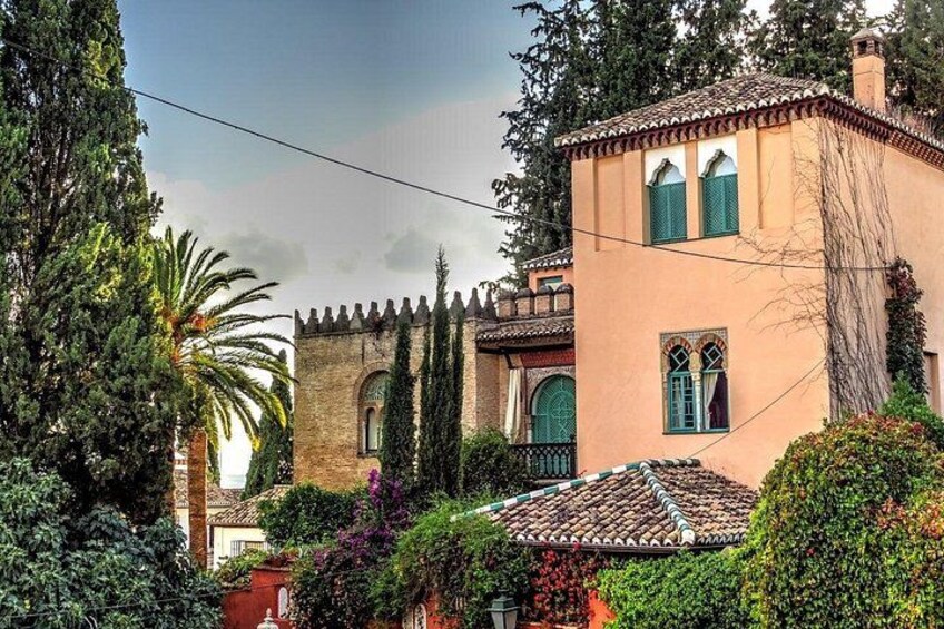 A Mediterranean-style building with a tiled roof, arched windows, and a stone facade. 2
