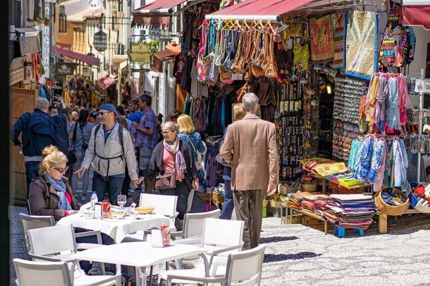 Un mercado al aire libre concurrido, gente comprando y mesas dispuestas para comer. 3