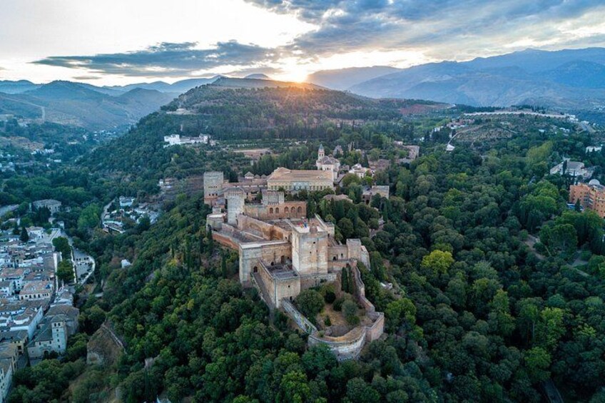 Un castillo histórico rodeado de un bosque denso, con un valle y montañas al fondo. 5