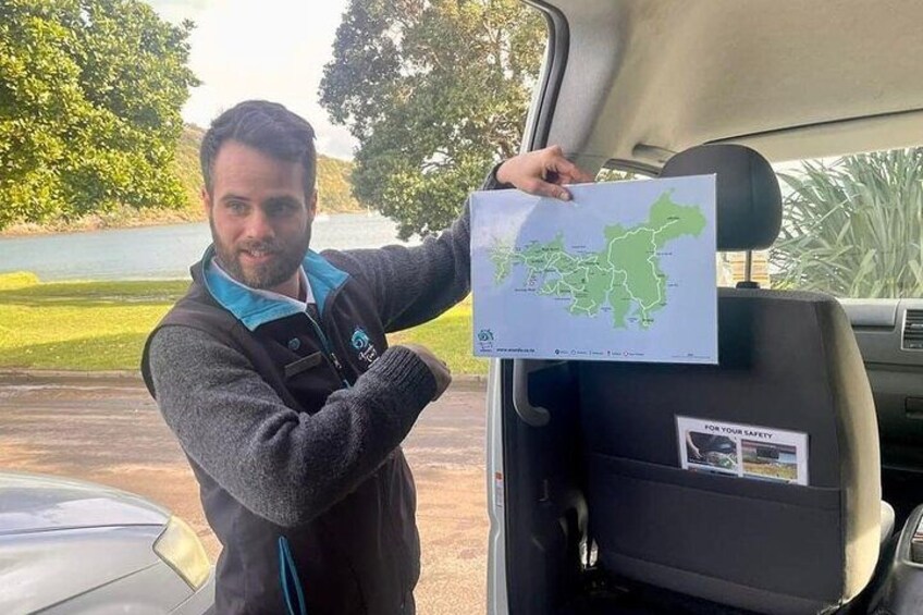 A person holding a map in the trunk of a car. 2