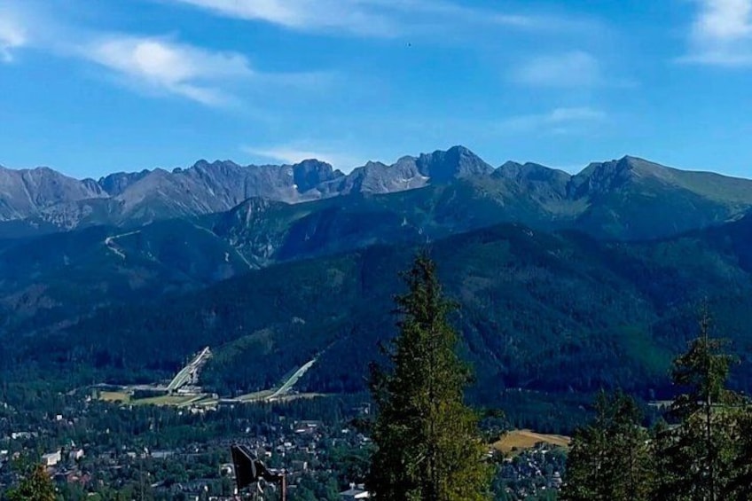 Una catena montuosa con una città in primo piano e cielo sereno. 1