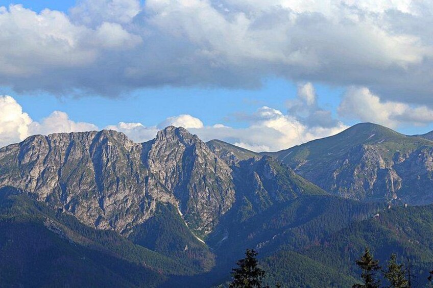 Una cordillera con picos escarpados y valles densamente boscosos. 2