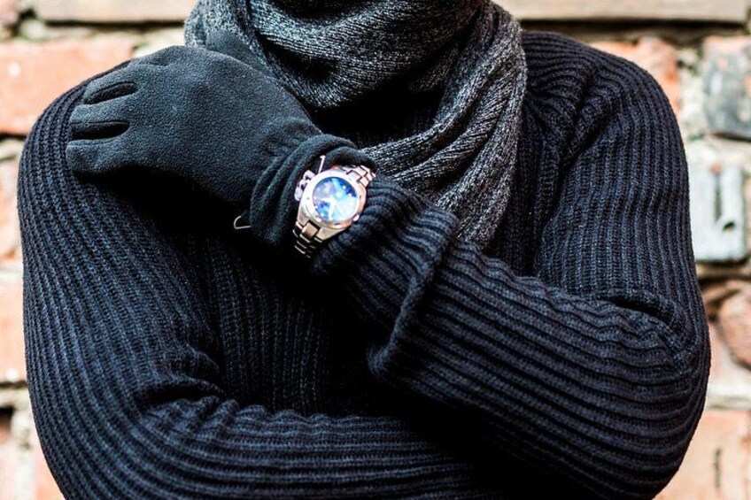 A person wearing a black sweater and a watch. 3