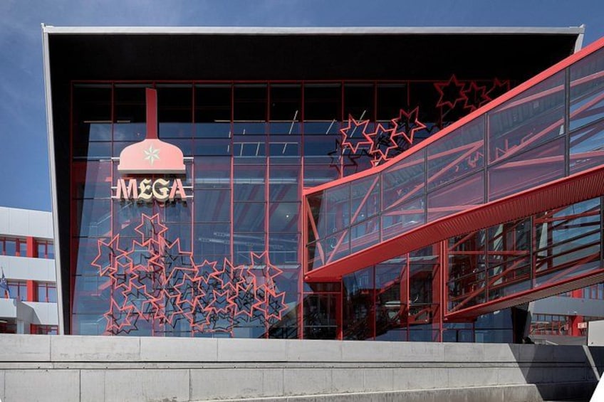Een modern gebouw met een glazen gevel en een opvallend MEGA logo. 2