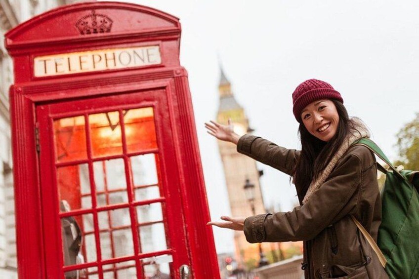 Une cabine téléphonique rouge, avec une personne debout devant. 4