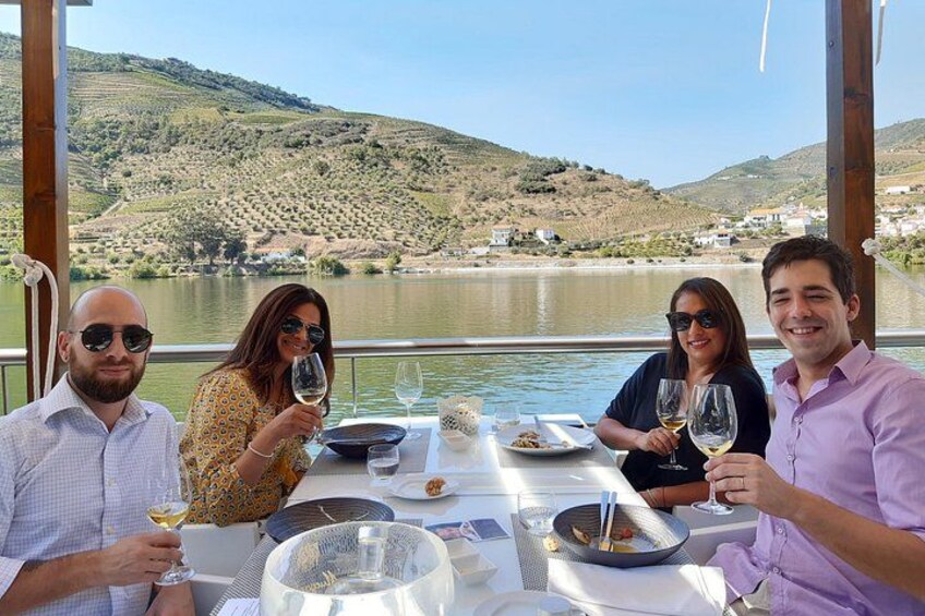 Un grupo de personas cenando en una mesa con vistas a un lago pintoresco. 1