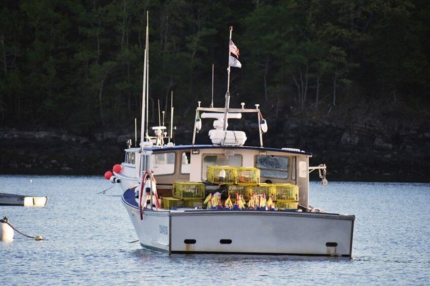 A boat with a flag, a cabin, and a netted area on the deck. 3