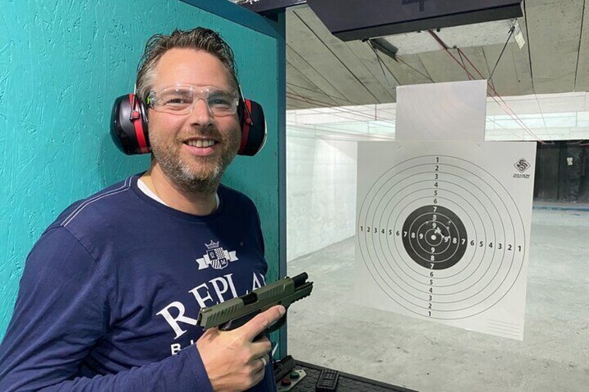 A person holding a handgun, aiming at a target with concentric circles. 4
