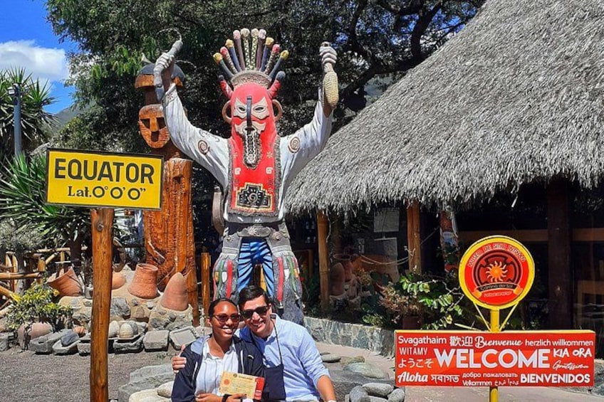 A traditional figure, a sign indicating the Equator, and a welcome sign. 1