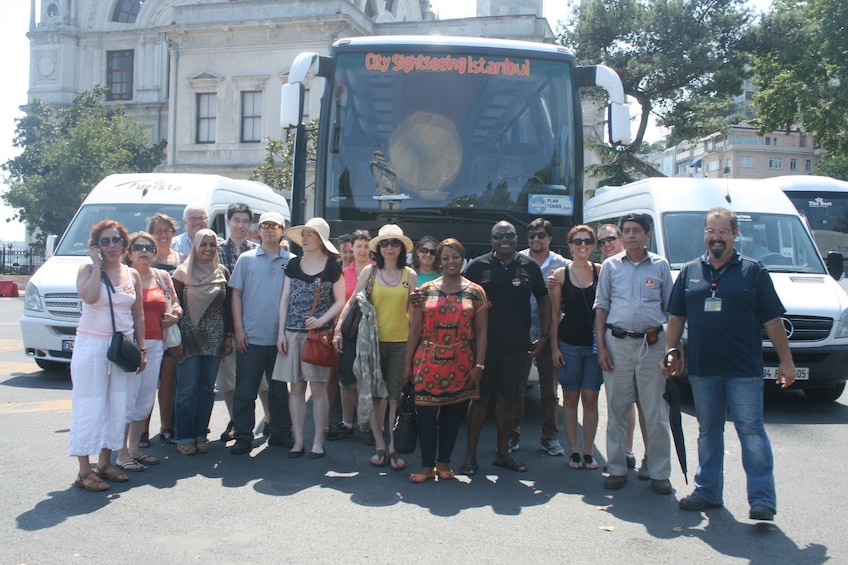 Un groupe de personnes posant devant un autobus touristique. 2