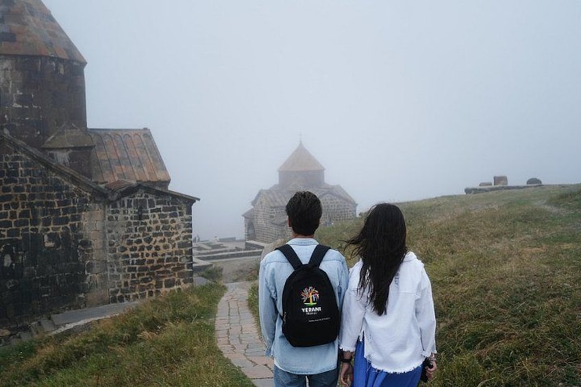 A couple walking on a stone path towards a historic building with domed structures. 4
