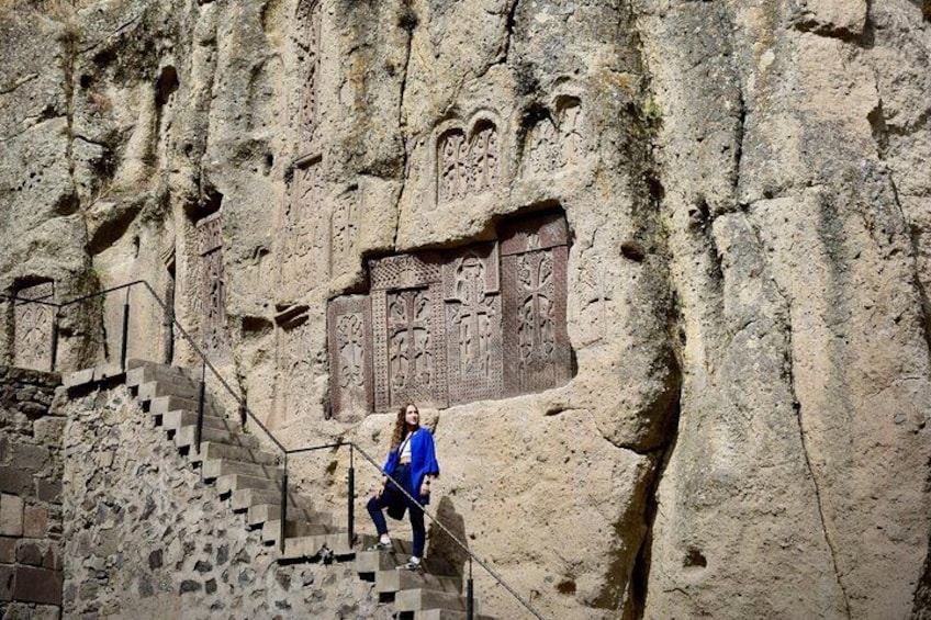 A person climbing a stone staircase with intricate carvings on the wall. 2