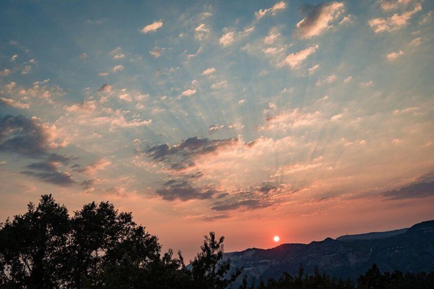 Ein Sonnenuntergang über einer gebirgigen Landschaft mit vereinzelten Wolken. 4